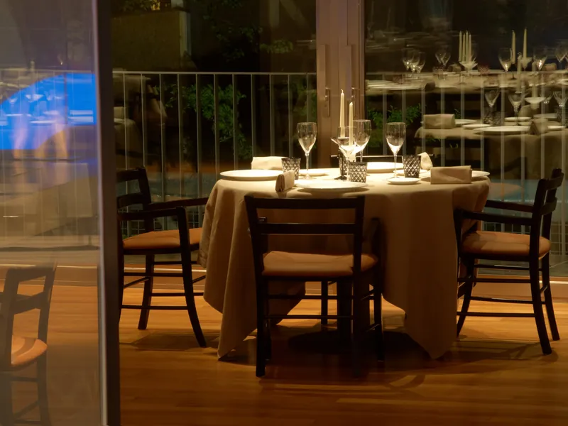 Gedeckter Tisch mit Kerzen und Weingläsern am Abend