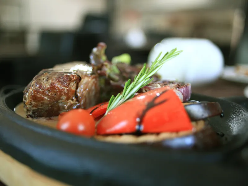 Geschmortes Fleisch mit Paprika und Rosmarin in einer gusseisernen Pfanne